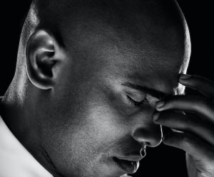 Tensed business man isolated against black background