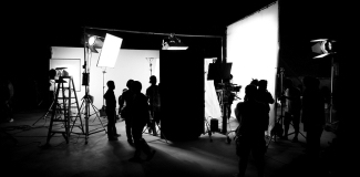 Silhouette images of video production behind the scenes or b-roll or making of TV commercial movie that film crew team working together with director in big studio.