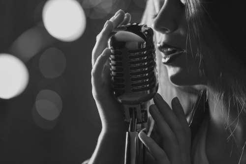 passionate female singer with microphone on stage, closeup