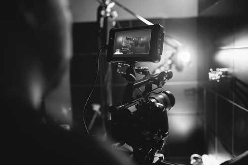 Video production backstage. Behind the scenes of creating video content, a professional team of cameramen with a director filming.