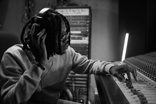 Male music arranger composing song on midi piano and audio equipment in digital recording studio