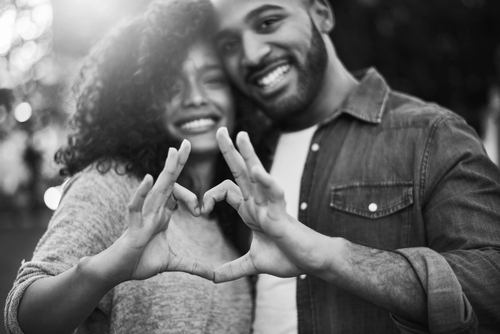 The heart knows what it wants. Portrait of a a young couple making a heart shape with their fingers outdoors. Supportive and intimate relationship concept. 
