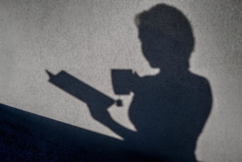 female shadow, reading a book with a cup of tea