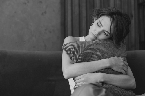 Women sooting herself using a pillow. 