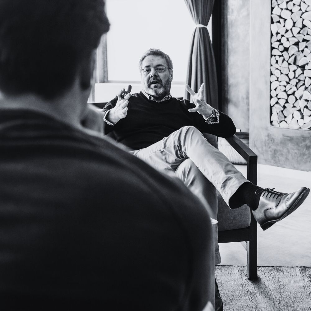 Male therapist talking and gesturing in a session