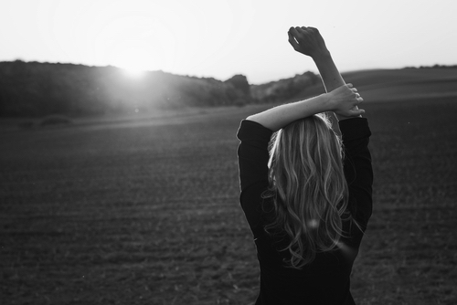 Young woman enjoys sun beams