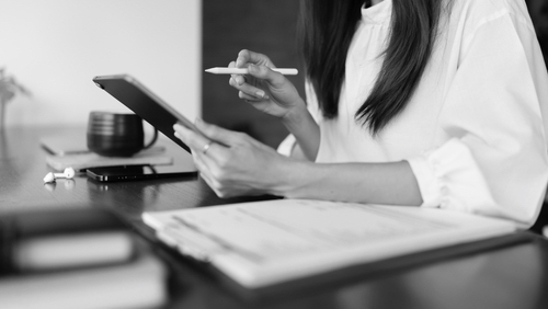 Writer woman is thinking creative ideas and writing business information content on tablet in cafe.