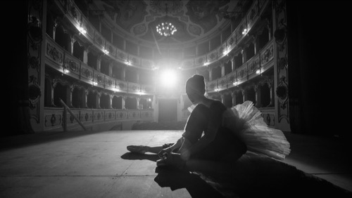 Female ballet dancer, alone, seated on the stage, no one in the audience - desire to be see and the ache of solitude and self doubt.