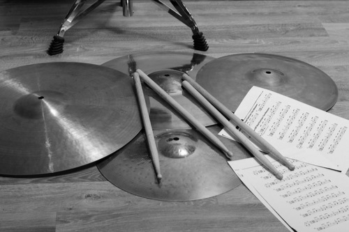 Drums symbols on the floor with music sheets - metaphor of music stopping, stalling 