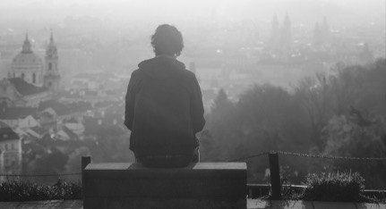 Man sitting and looking outward at the city symbolizing emotional awareness 
