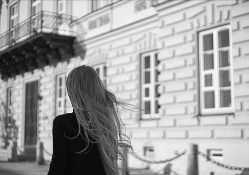 Female walking strong in the city, hair in the wind, image of stepping out and reconnecting with herself 