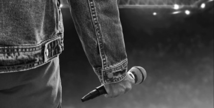 Man back view, holding a microphone. 