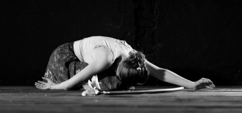 Female dancer bowing on the stage, flowers next to her form her audience. Image of healing performance anxiety.