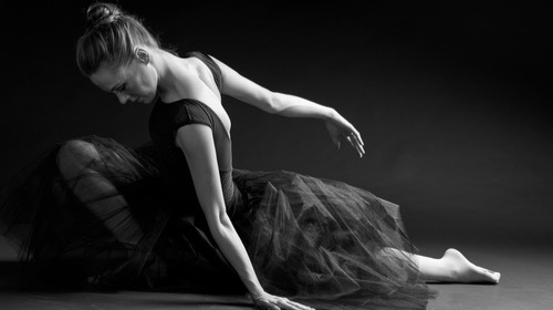 Female dancer leaning on the stage before a dance jump.